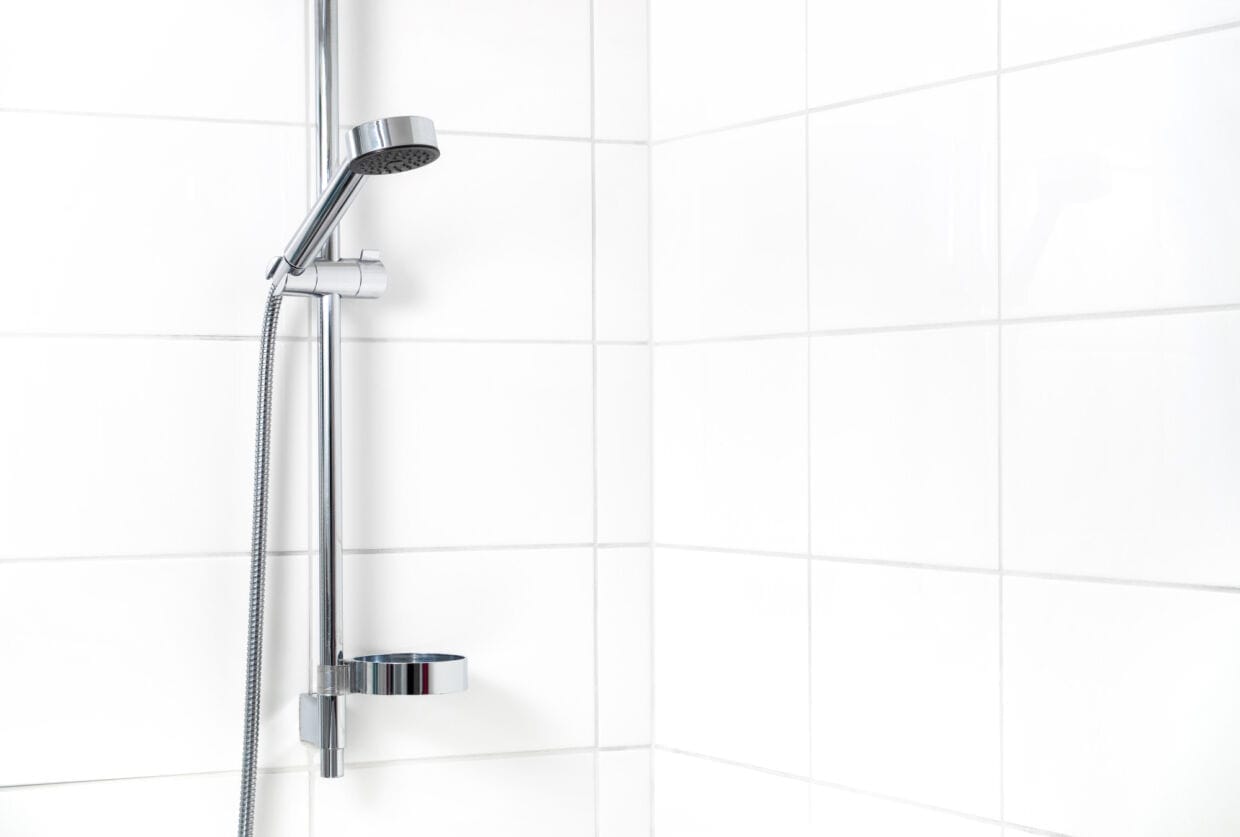 Modern shower with white wall tiles. Simple stylish Scandinavian home interior design. Clean fresh bathroom.